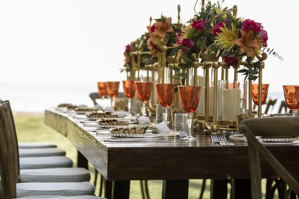 A table with plates, glasses, and flowers. Host events regularly for your sphere of influence in real estate