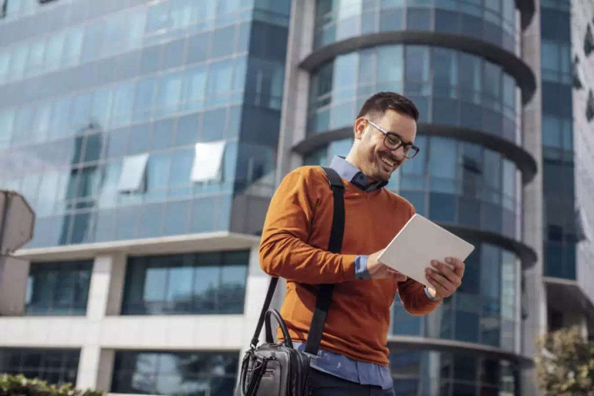 Successful Modern Young Real Estate Agent Using a Digital Tablet on the Street