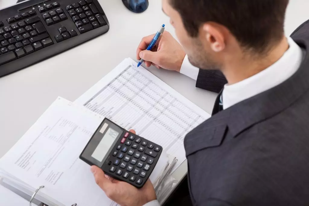 A woman typing on a calculator