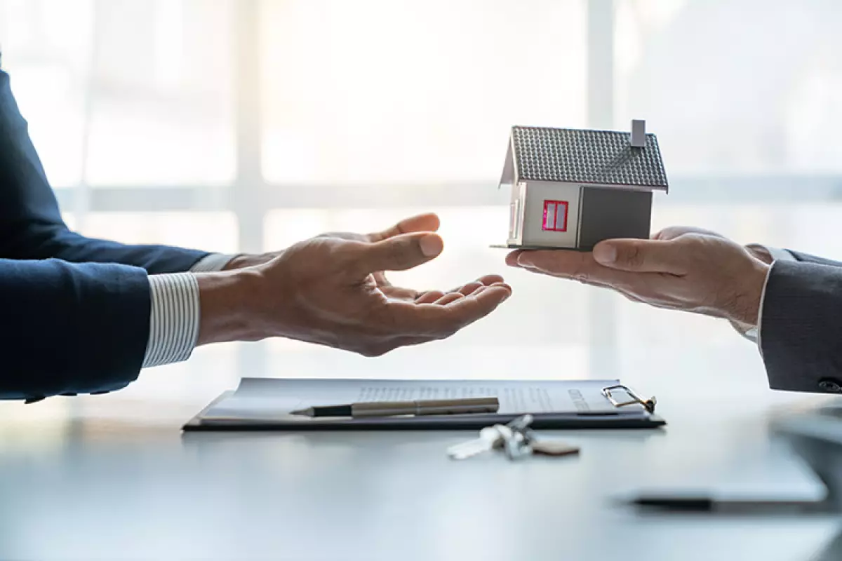 Two professionals sharing a project in the form of a model house.