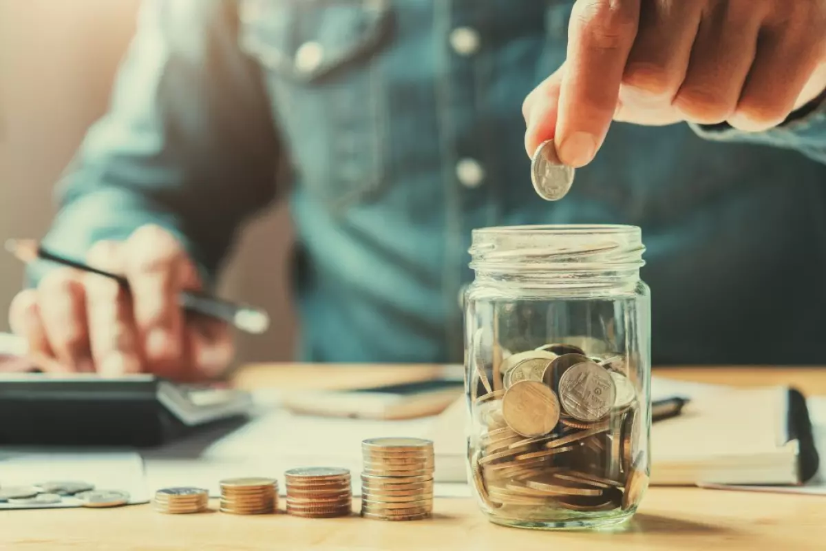 A man putting money into a jar