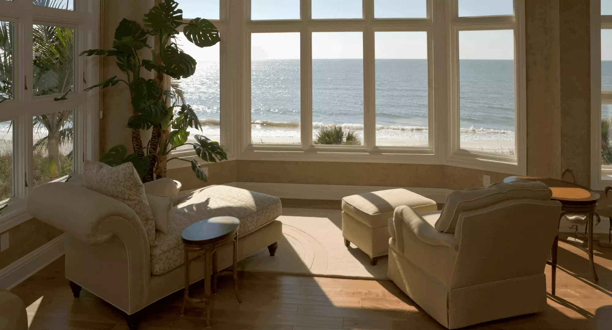 Lounge area with stunning bay window overlooking the sea. Charm in the decor and furnishings using a neutral palette.