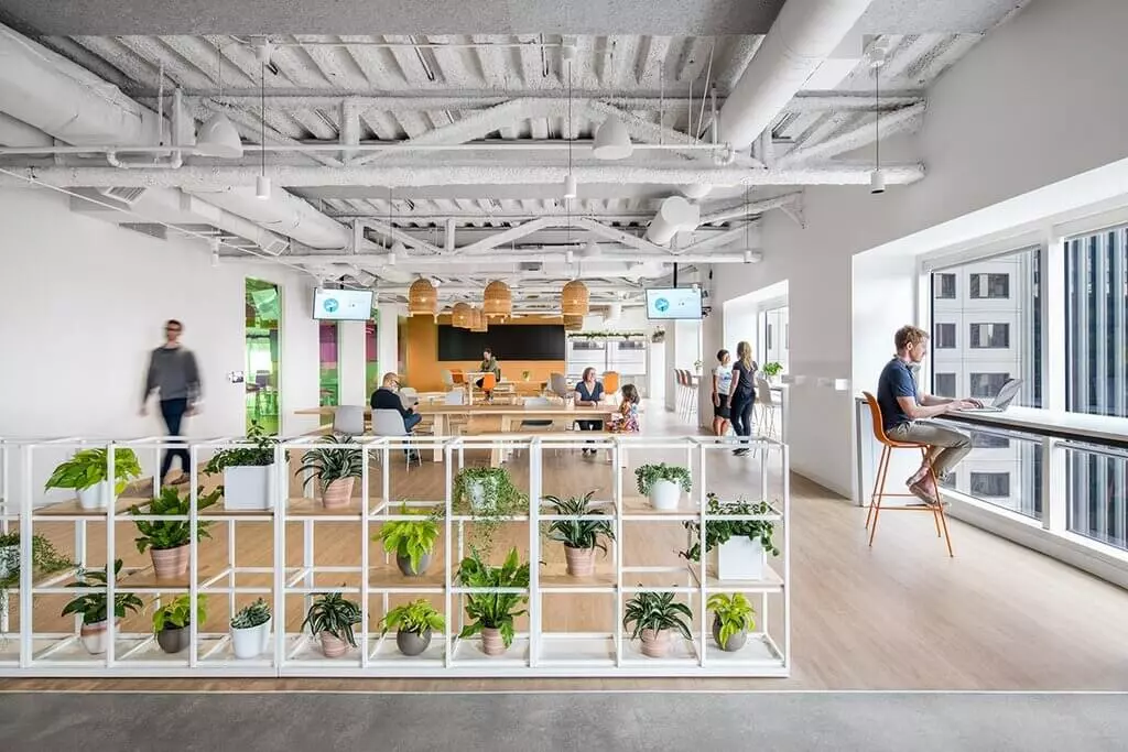 A room filled with lots of computer desks and chairs