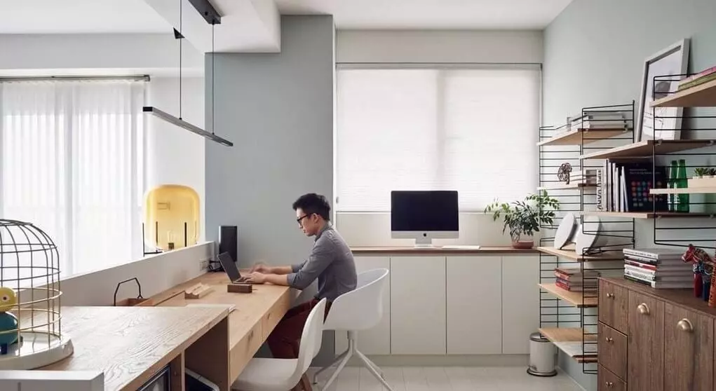 A room with a desk, chairs, and pictures on the wall