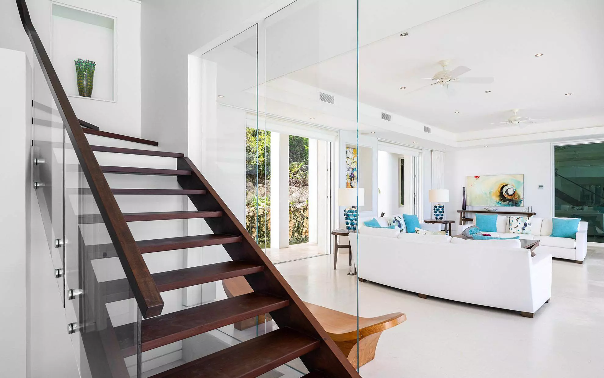 Beautiful modern staircase design featuring open risers and glass railings. Dark brown stain with matching wood handrail. Glass side wall.