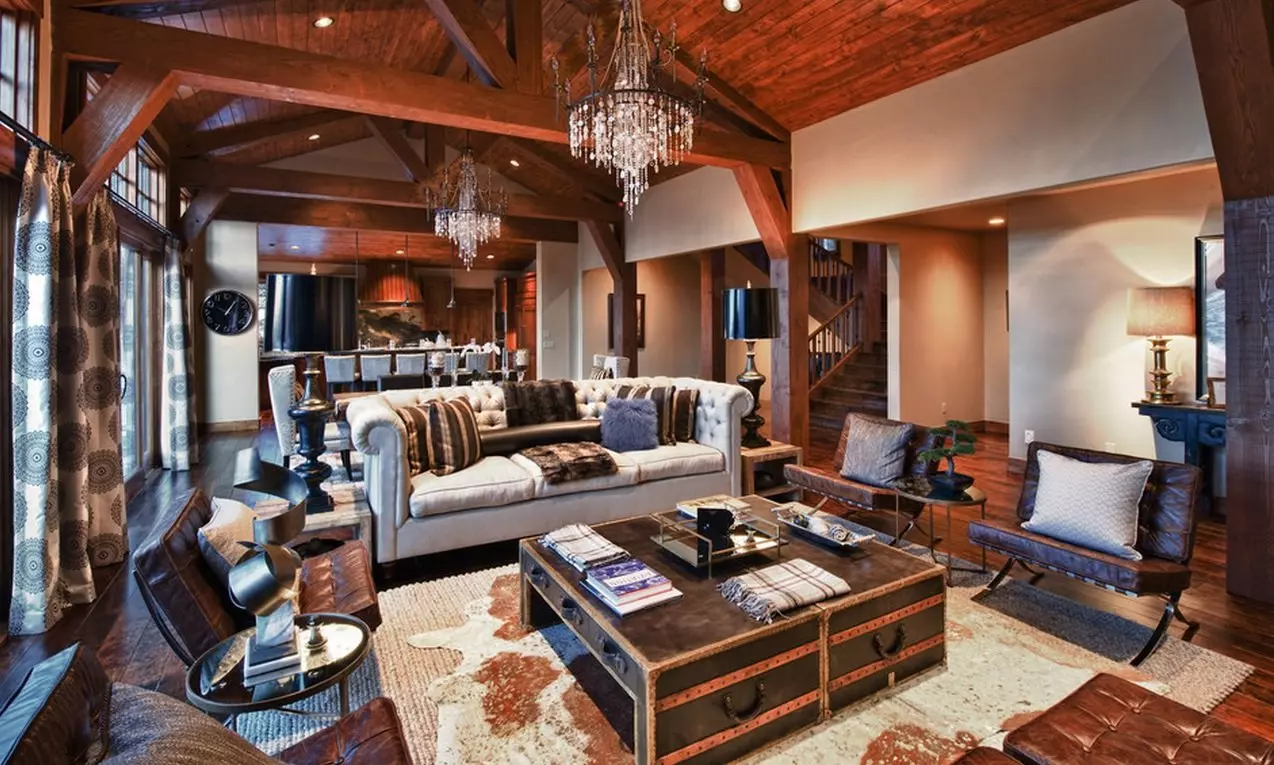 Great castle-looking interior design with wooden transom ceiling, cow pelts, and chest coffee table