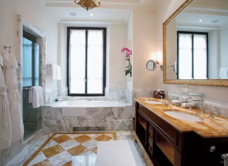 Marble-sided bathtub and tiled floor in the bathroom