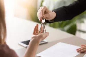 landlord shaking hands with tenants in empty apartment