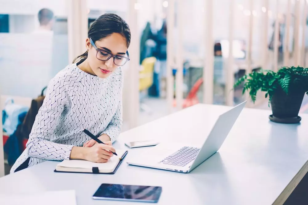 Two female business women working in an office setting