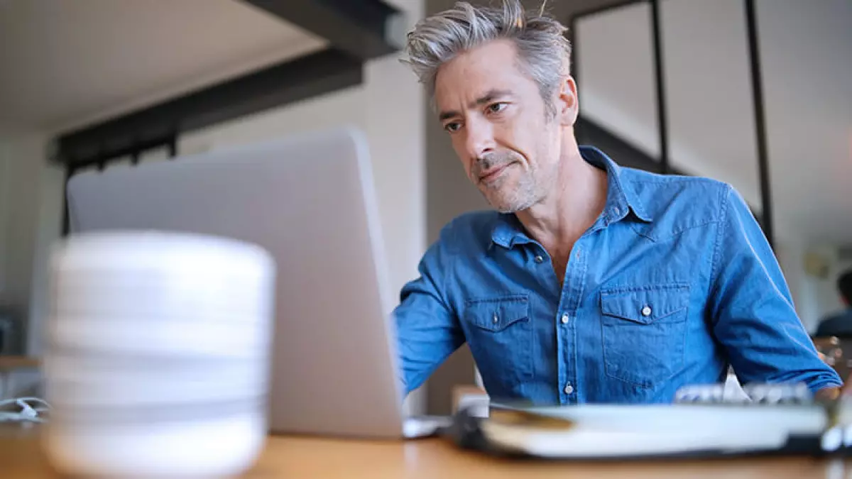 man-serious-looking-at-computer grey hair