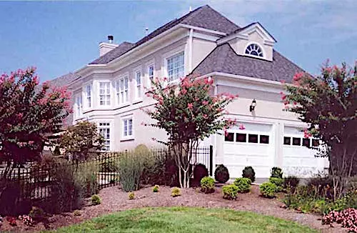 Country style home with stone and wood siding and decorative gable ends