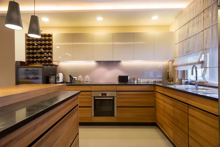 Kitchen with wall mounted floating wood cabinets, center island, tile backsplash, and windows