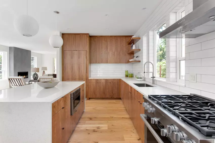 Kitchen with cabinets that float, wood backsplash, ceiling beams, island, chairs, and pendant lights