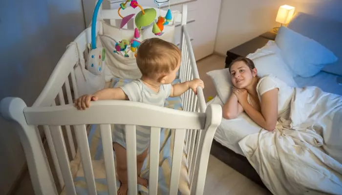 Baby girl in wood crib