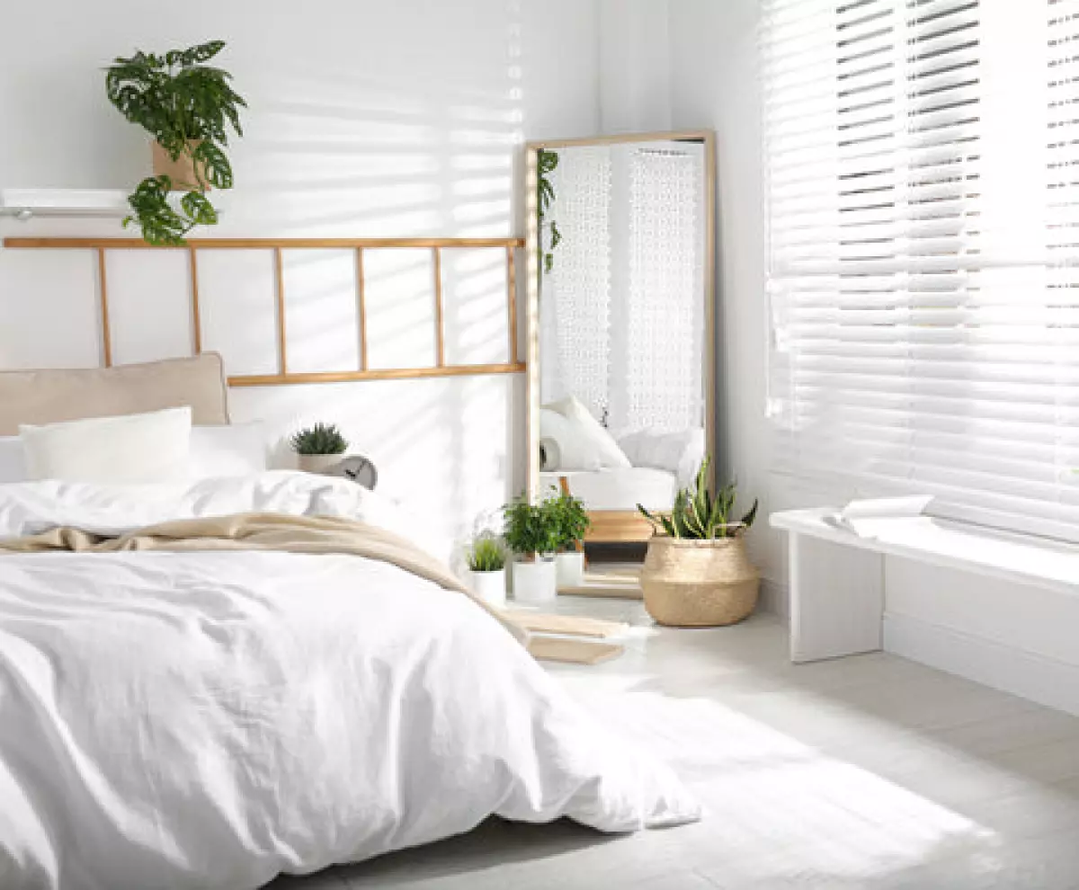 Mirror placed in the corner of all white bed room according to Feng Shui