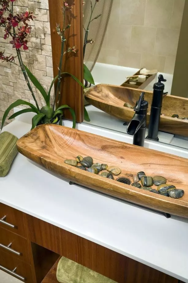 a Zen-inspired bathroom sink with river rocks on the bottom