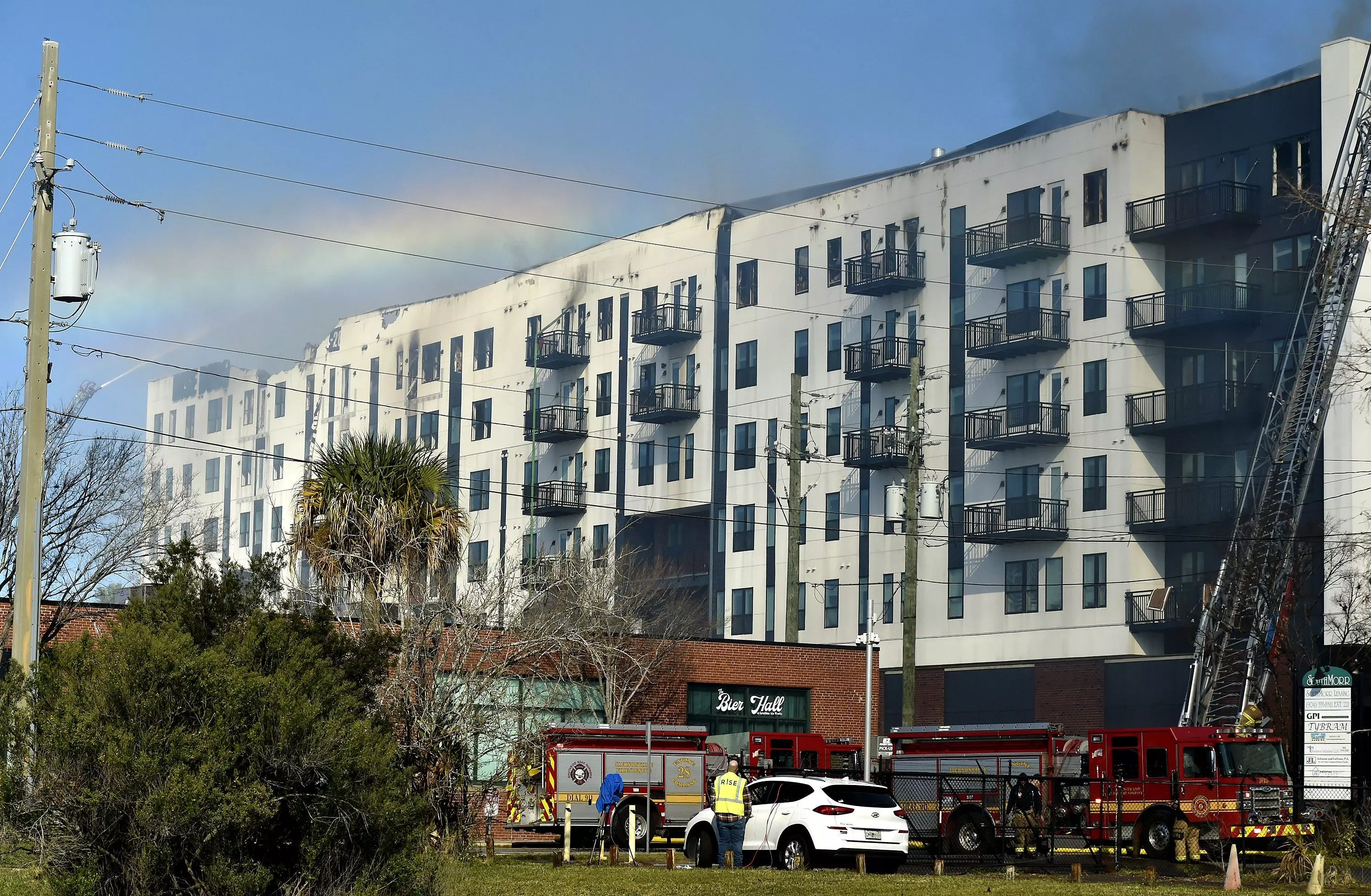 A rainbow forms in the spray of fire hoses trying to knock down the last of the hot spots in the fire-gutted RISE Doro apartment building Monday.