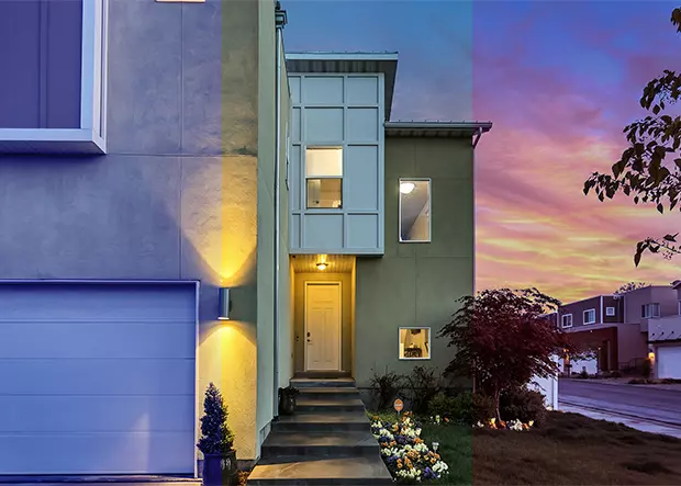 Home exterior with fluorescent lighted door and beautiful sunset sky in the background