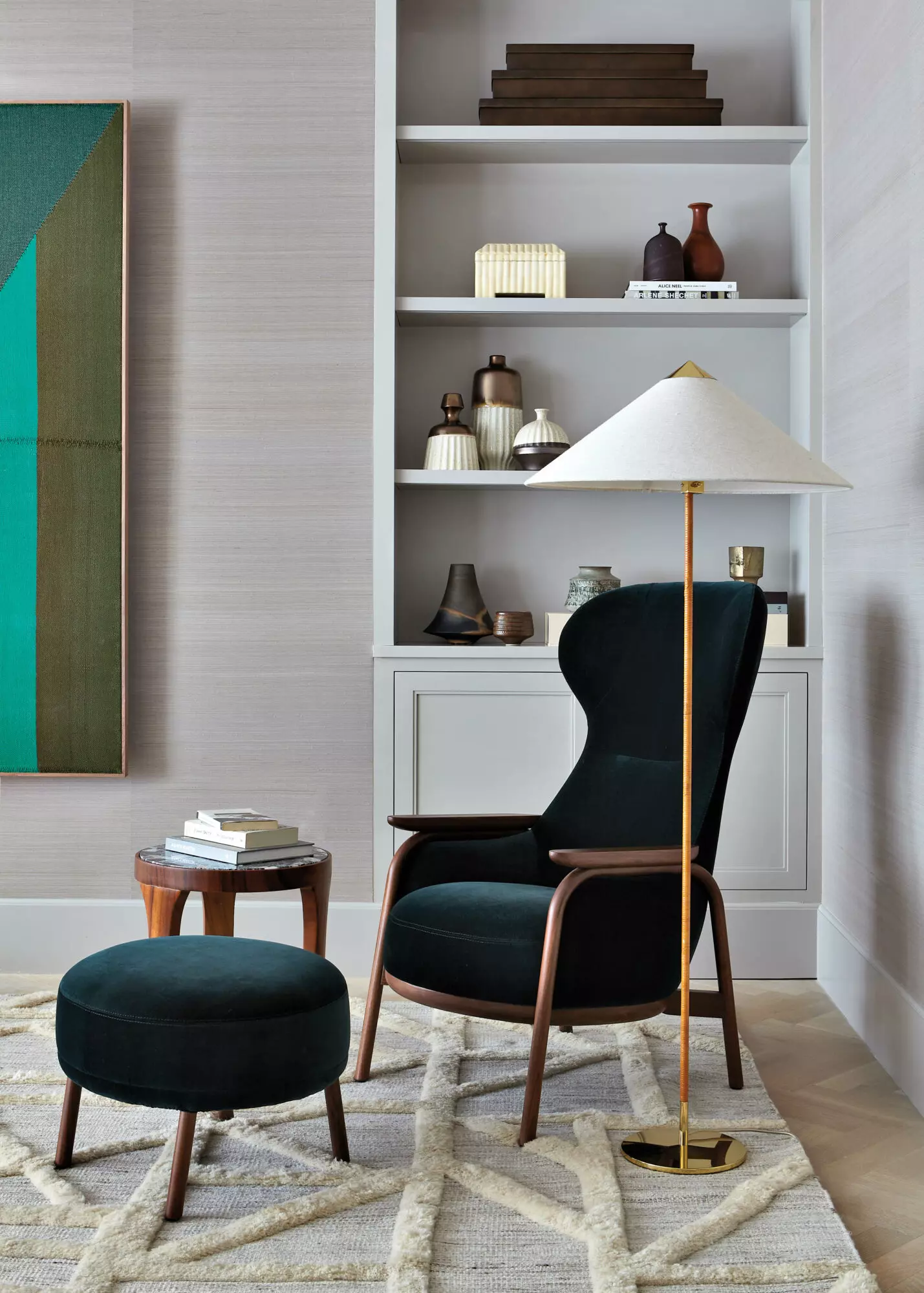 bedroom with green velvet lounge chair, tall white wicker floor lamp and light green bookshelf