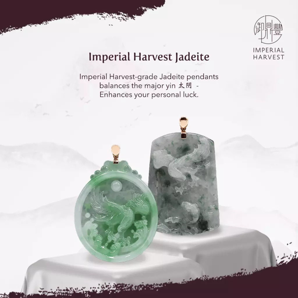 A hand holding a jadeite pendant.