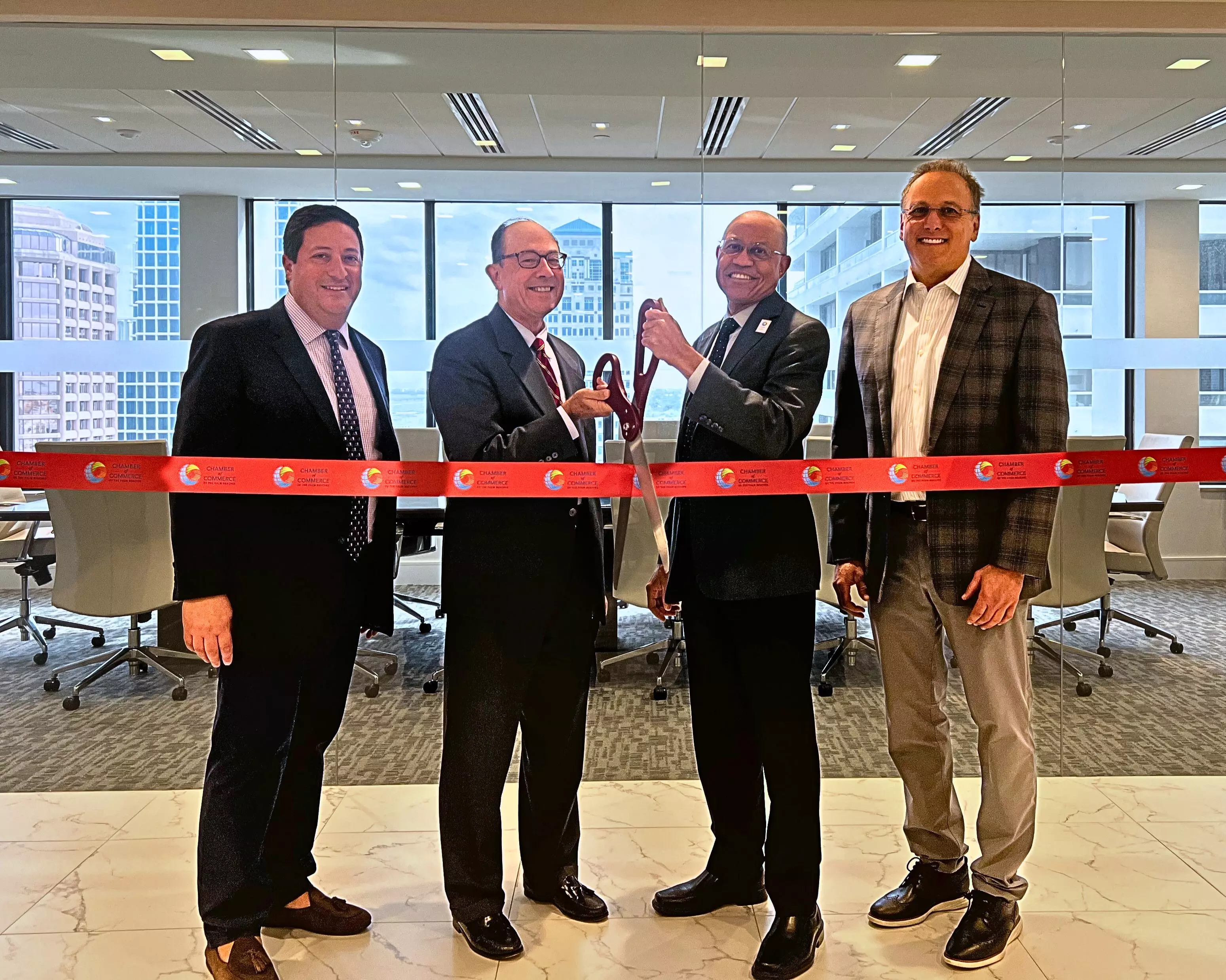 Jones Foster vice chair Theo Kypreos (left), chairman Scott Hawkins (second from left) and board member Steve Rothman (far right), join Chamber of Commerce of the Palm Beaches CEO Donald Burgess for a ribbon-cutting ceremony at their West Palm Beach office to celebrate the firm