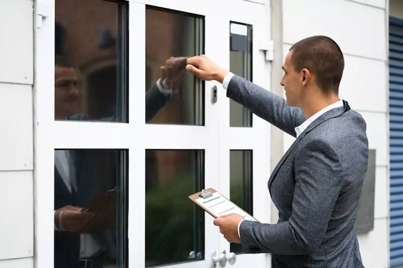 People discussing in front of a house, suggesting inquiries about the property owner