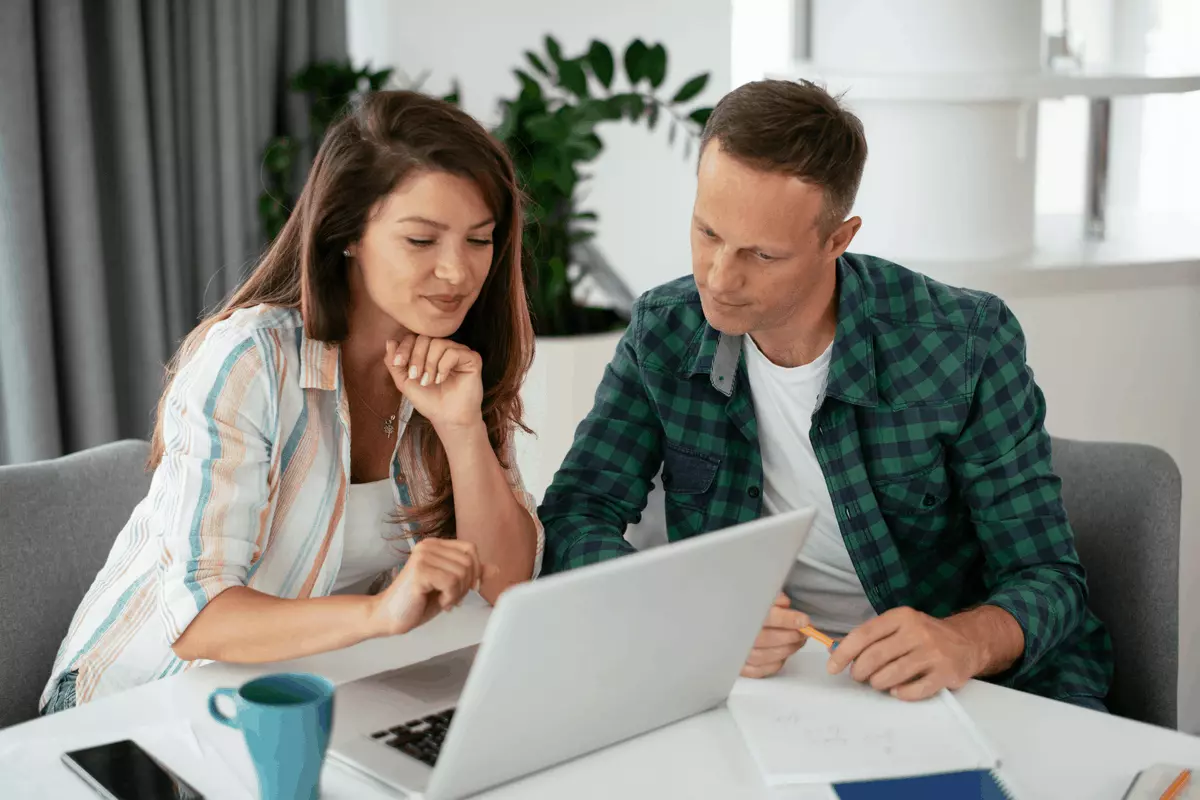 A couple at a laptop reviewing documents and looking for no credit check apartments