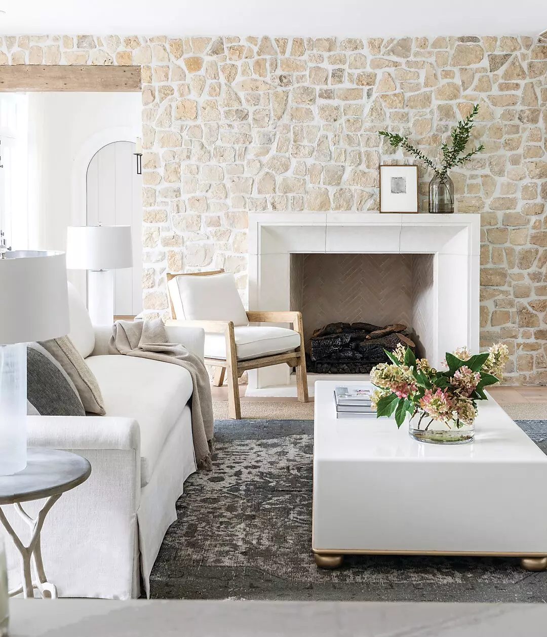 A room designed by Marie Flanigan featuring earthy tone furnitures and a white wall